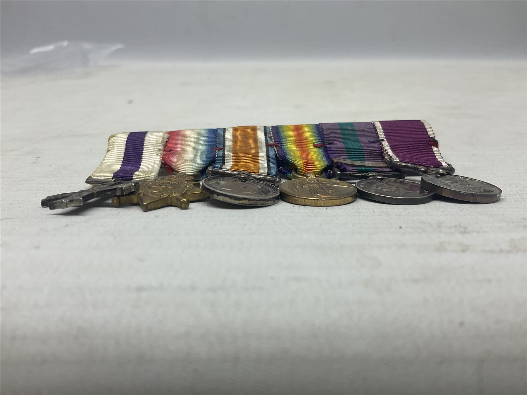 George V Military Cross miniature group of six medals comprising MC, WW1 trio including 1914 Star, Long Service and Good Conduct Medal and General Service Medal with Iraq clasp; and miniature group of four medals comprising Military OBE and WW1 trio including 1914-15 star; all with ribbons and both on pinned wearing bars