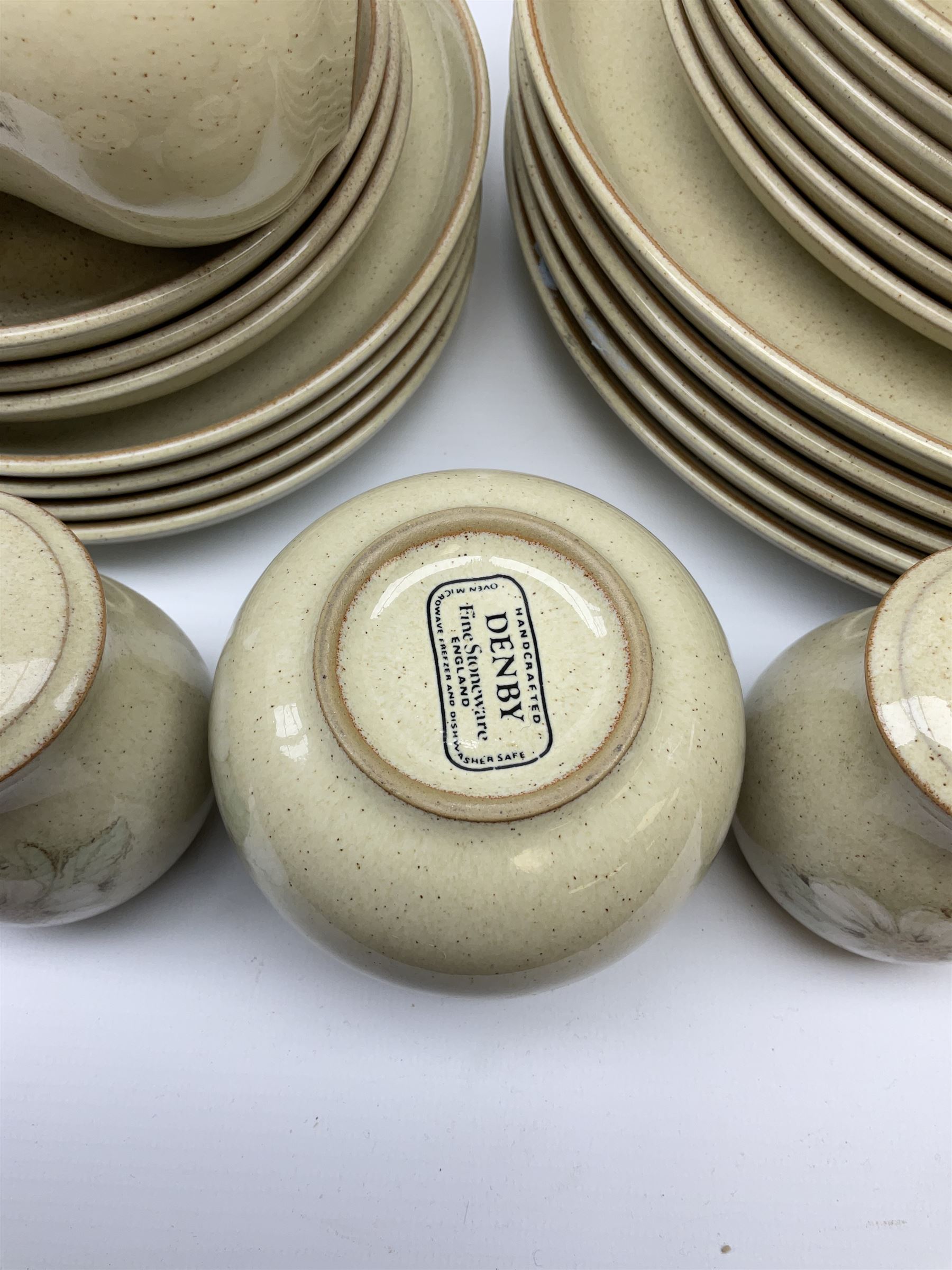 Denby tea and dinner ware decorated in the Daybreak pattern, comprising of tea pot, two jugs, seven cups and six saucers, salt and pepper shakers, four oval platters, six side plates, starter plates, dinner plates and bowls.
