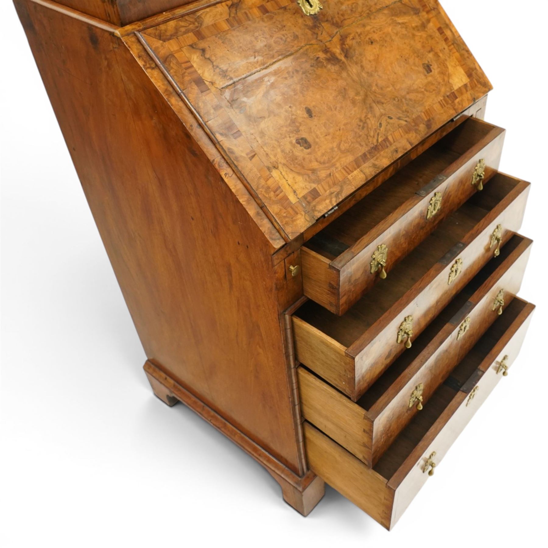 Quality George I figured and burr walnut bureau-cabinet of unusually small proportions, the projecting cavetto cornice over a glazed and banded door enclosing four adjustable shelves, with a candle slide below, the book-matched and banded veneer fall-front enclosing a fitted interior with pigeonholes, correspondence drawers and original trinket boxes and inkwells, over two pull-out stays and four graduating long drawers with banded facias and pressed brass escutcheons and pull handles, lower moulded edge on bracket feet
Provenance: purchased Sotherby's 1977