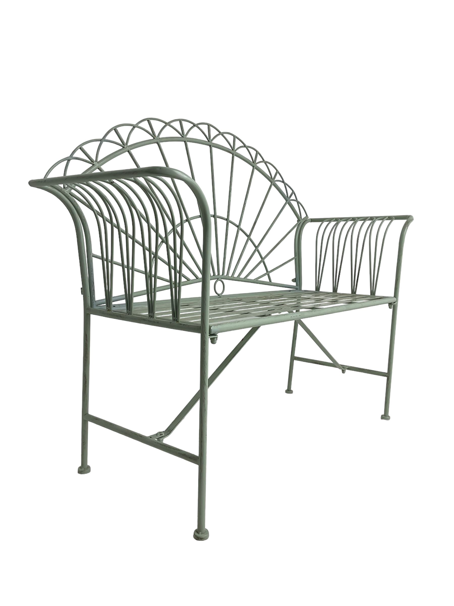 Regency design wrought metal bench, the fan back over out-swept arms, strap seat on supports united by stretchers, in pale teal finish