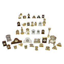 Collection of miniature clocks, predominantly with quartz movements, to include example modelled as an armchair, Edinburgh crystal glass example, clock modelled as a flower, sewing machine etc