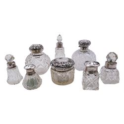 Group of eight silver mounted glass dressing table scent bottles and jars, of various size and form, to include Victorian example with cut glass globular body and scroll embossed hinged cover, hallmarked Colen Hewer Cheshire, Birmingham 1876, H9cm, other examples with various hallmarks, dates ranging 1897 to 1928