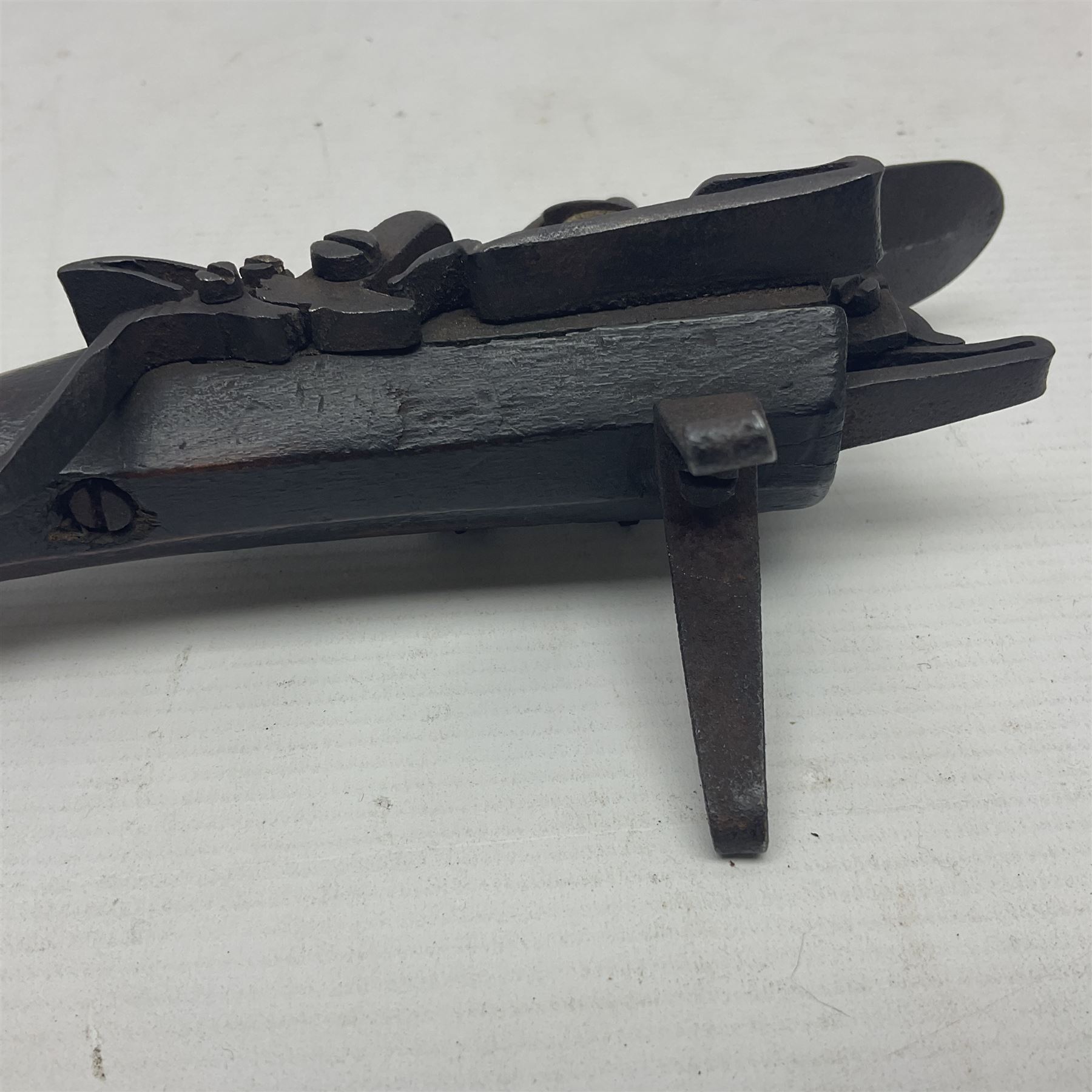 Late 18th/early 19th century flintlock tinder lighter, the steel box lock with hinged door to the left side, fruitwood butt with plain bar trigger, the left side set with a taper sconce and bipod front support, L21cm.