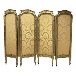 Late 19th/early 20th century French Rococo style gilt wood and gesso dressing screen, four double hinged panels, each with shaped cresting rail over shell and floral frieze, moulded frame with flower head and scroll decoration, acanthus leaf cabriole supports with castors, upholstered in gold Damask fabric