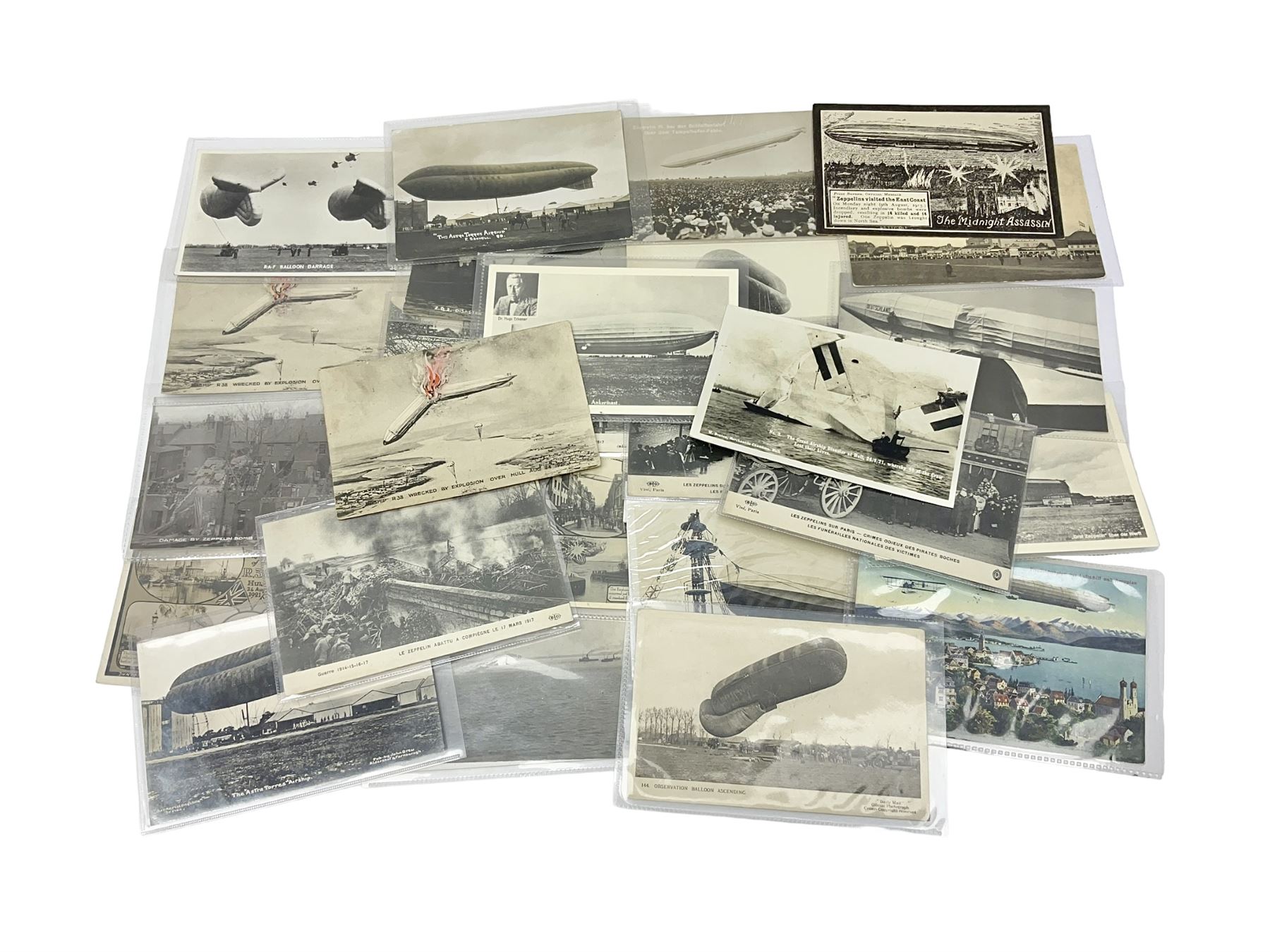 Collection of twenty six postcards depicting Airships/Zeppelins, including two pairs depicting the tragedy of the R.38. wrecked over Hull August 24th 1992, many unused.