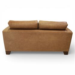 Modern two seat sofa in tanned leather, loose seat and base cushions, block arm rests above dark stained block supports 