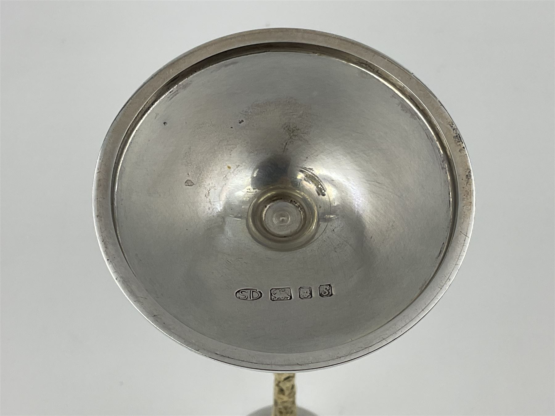 Pair of modern silver candlesticks by Stuart Devlin, the tapering parcel gilt stems with signature textured detailing, each supporting a fluted candle holder and upon a spreading circular foot, hallmarked Stuart Devlin, London 1973, H25cm