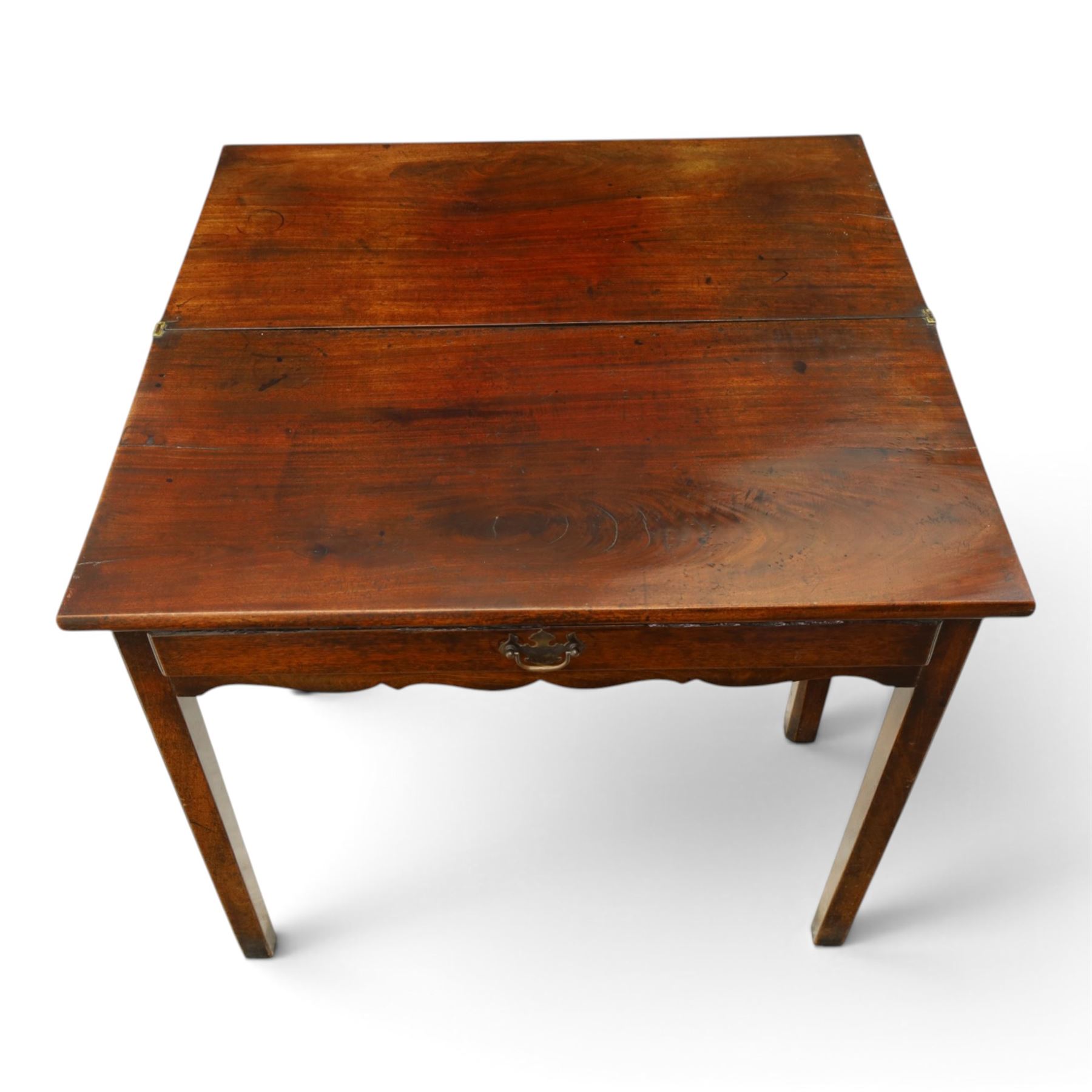 Georgian oak tea table, rectangular fold-over top above single frieze drawer with brass swing handle, shaped apron, gateleg raised on square tapering supports