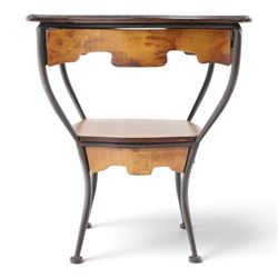 Art Nouveau style occasional table, serpentine shaped top with dark moulded edge, shaped apron and lower shelf, raised on four curved metal supports