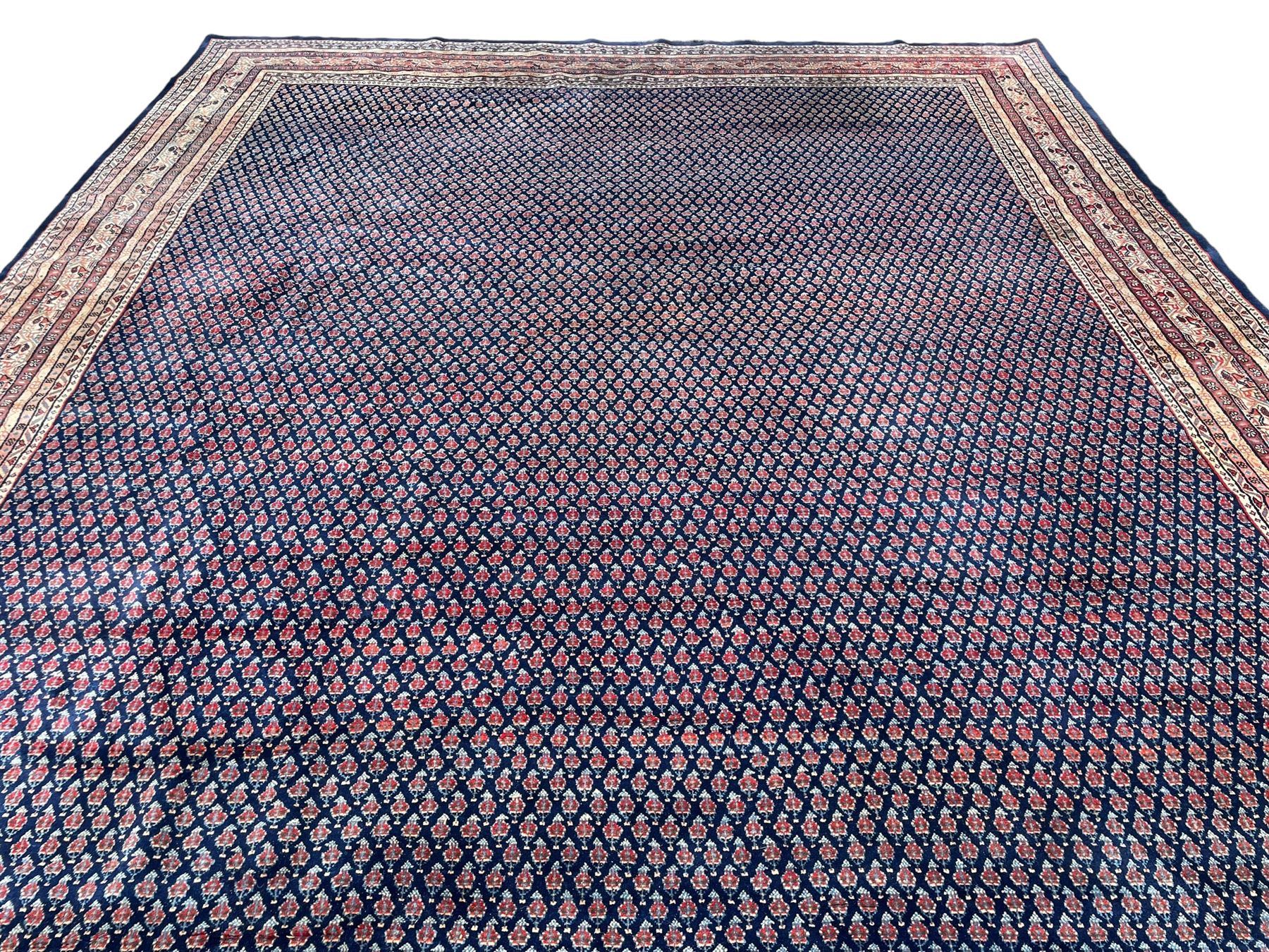 Large North-West Persian Arrak indigo ground carpet, the field decorated all-over with small Boteh motifs, multiple band border decorated with repeating geometric designs