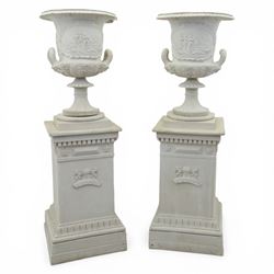 Pair of composite campana urns on stands, the urns decorated with relief figural panels an...