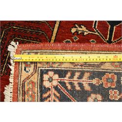 Anatolian crimson ground tribal rug, the field decorated with repeating geometric tree of life motifs with figural designs, the indigo guard band with stylised palmettes
