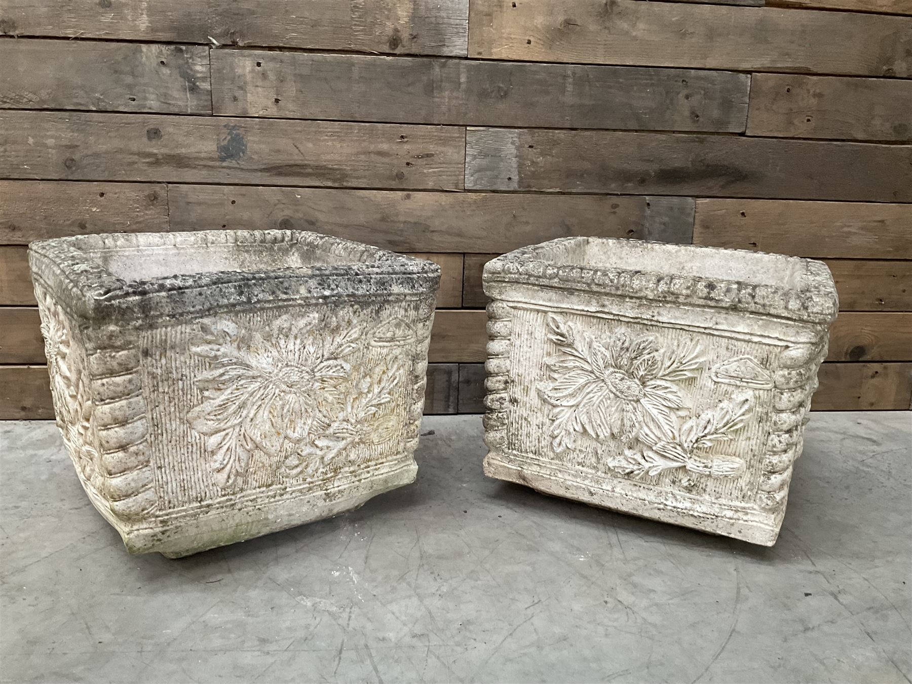 Pair of weathered cast stone square garden planters, leaf decoration