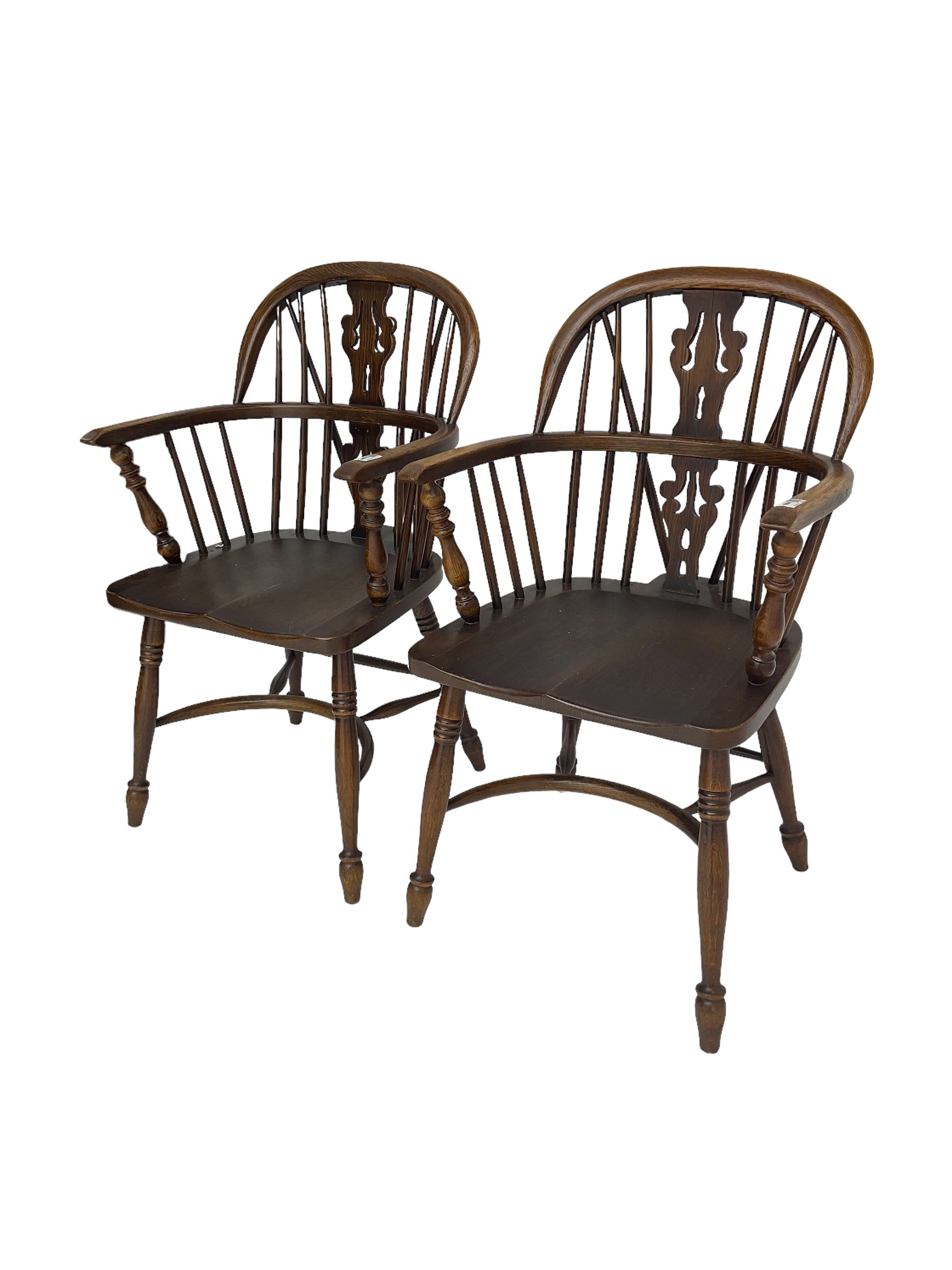 Pair late 20th century oak Windsor elbow chairs, double hoop and stick back with pierced and fretwork work splat, dished seat on turned supports joined by crinoline stretcher