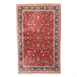 Persian Kashan crimson ground rug decorated with scrolling foliage, the indigo guard strip...