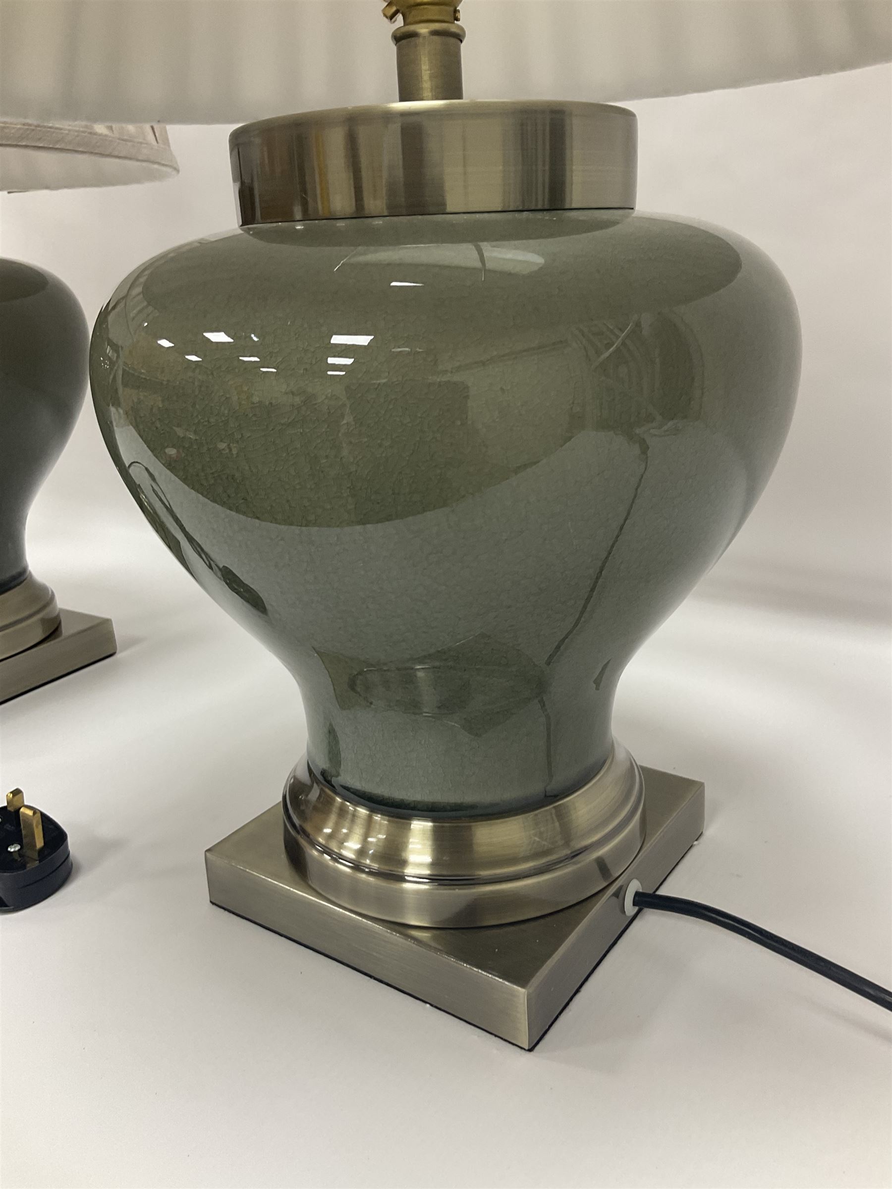 Pair of table lamps of squat baluster form, with a crackle glaze to a dark grey ground, upon a square base, including shade H57cm