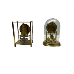 A 20th century English Torsion clock marketed by Bentime Ltd, London, with a four-ball rotary pendulum, white dial with gilt Arabic numerals and pierced gilt hands, under a glass dome, base with adjustable feet. No key.
Bentime Ltd did not make clocks but marketed clocks made by other companies such as J D Francis and Perivale.
H17
With a German Kundo torsion clock in a glazed rectangular case with four glass sides, four-ball rotary pendulum, white painted dial with gilt three-hour Arabic numerals and batons, with pierced brass hands. No key.
H15 W11 D9
