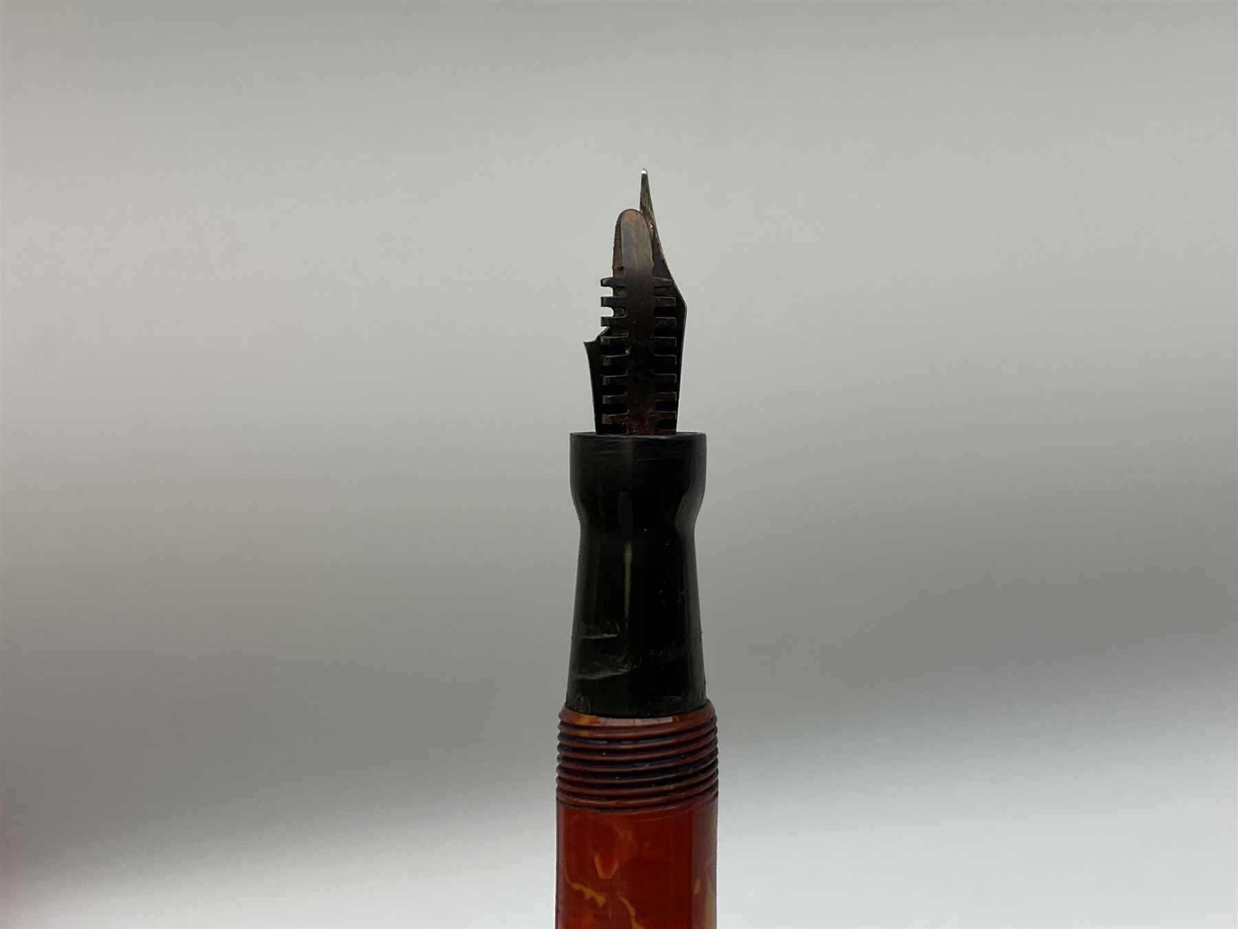 Vintage Swan Mabie Todd lever fill fountain pen in coral red, the nib a/f marked 14K, together with two further vintage Swan Mabie Todd fountain pens, the first example with lever fill, the other leverless, each with black body, one with nib marked 14ct, (3) 