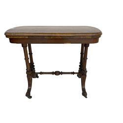 Victorian walnut stretcher side table, swivel fold-over top with baize lining, on pillar supports joined by turned stretcher, splayed feet with acanthus carved terminals, on castors
