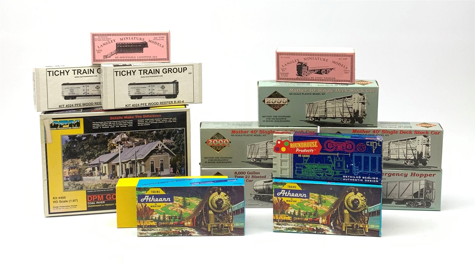 HO scale - nine American goods wagon plastic construction kits comprising three Proto 2000 Series Mather 40' Single Deck Stock Cars and 50 ton War Emergency Hopper, two Tichy Train Group 4024 Wood Reefers, two Athearn hopper wagons and Roundhouse Caboose; together with DPM Gold Coal River Passenger and Freight Depots and two Langley Miniature Models lorry kits, all boxed (12)