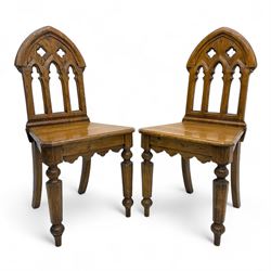 Pair of late 19th-century Gothic revival oak hall chairs, arched back with pierced quatref...