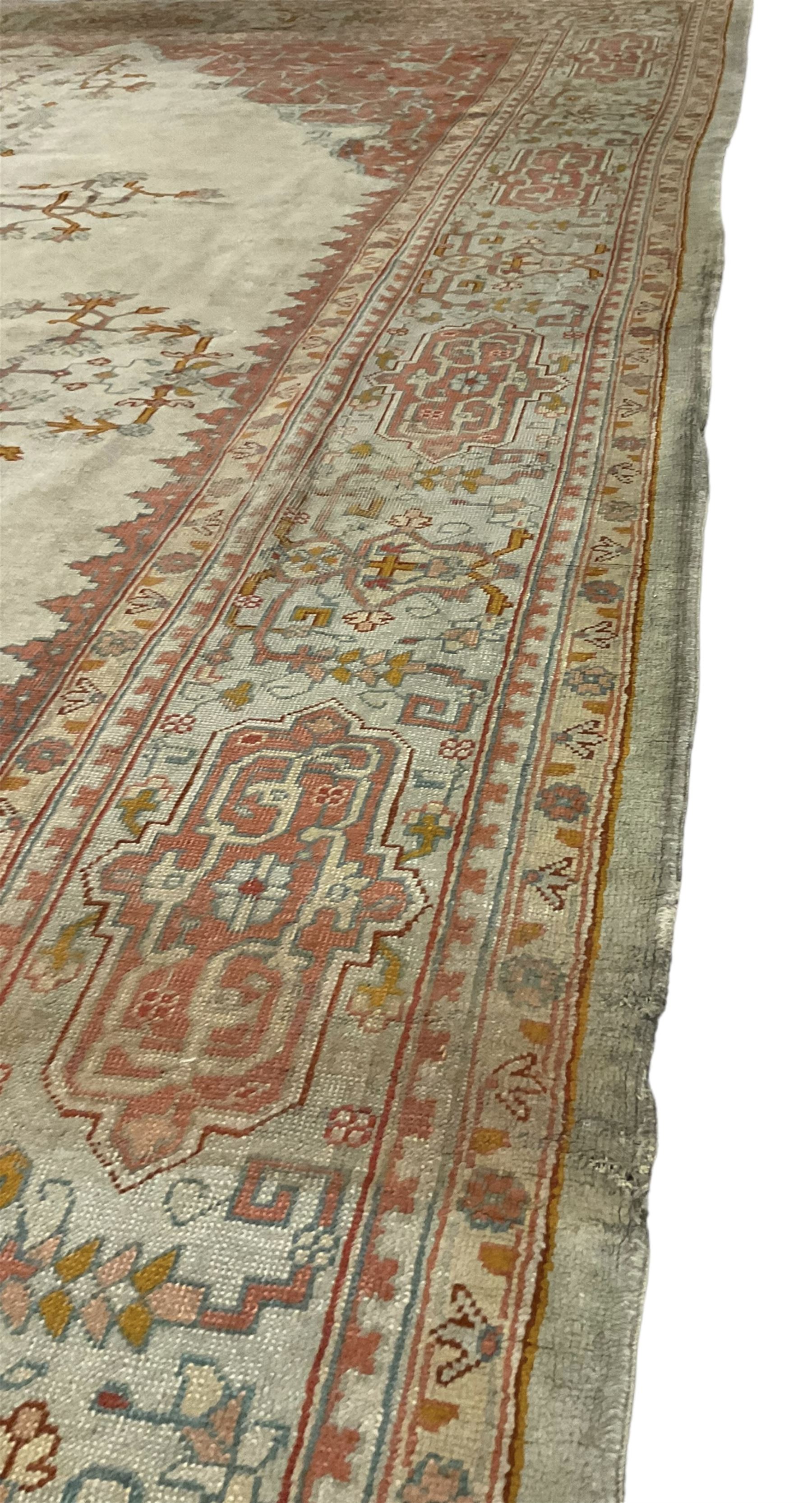 Large Persian pale sage ground carpet, the field decorated with central geometric medallion and tree of life motifs, the border with repeating geometric design decorated with stylised plant motifs