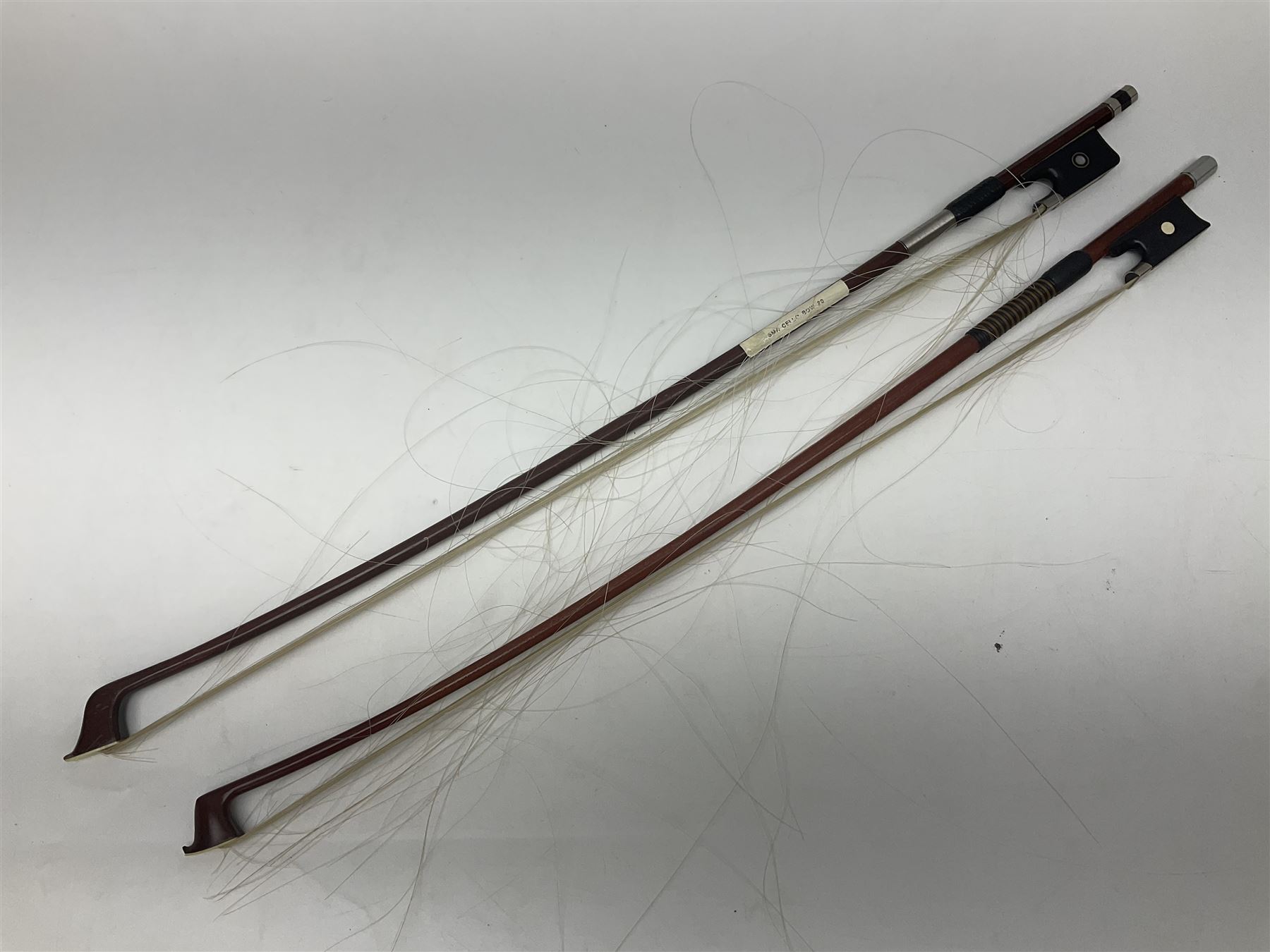 Two student half-size cellos - Boosey & Hawkes Artia with 65cm one-piece back and spruce top; bears maker's label; L104cm overall; and Romanian with 65.5cm two-piece maple back and ribs and spruce top; bears label; L108.5cm overall; each in soft carrying case with two bows (2)