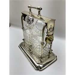 Early 20th century silver plated tantalus by John Grinsell & Sons of Birmingham, containing two crystal glass decanters, with key, H31cm
