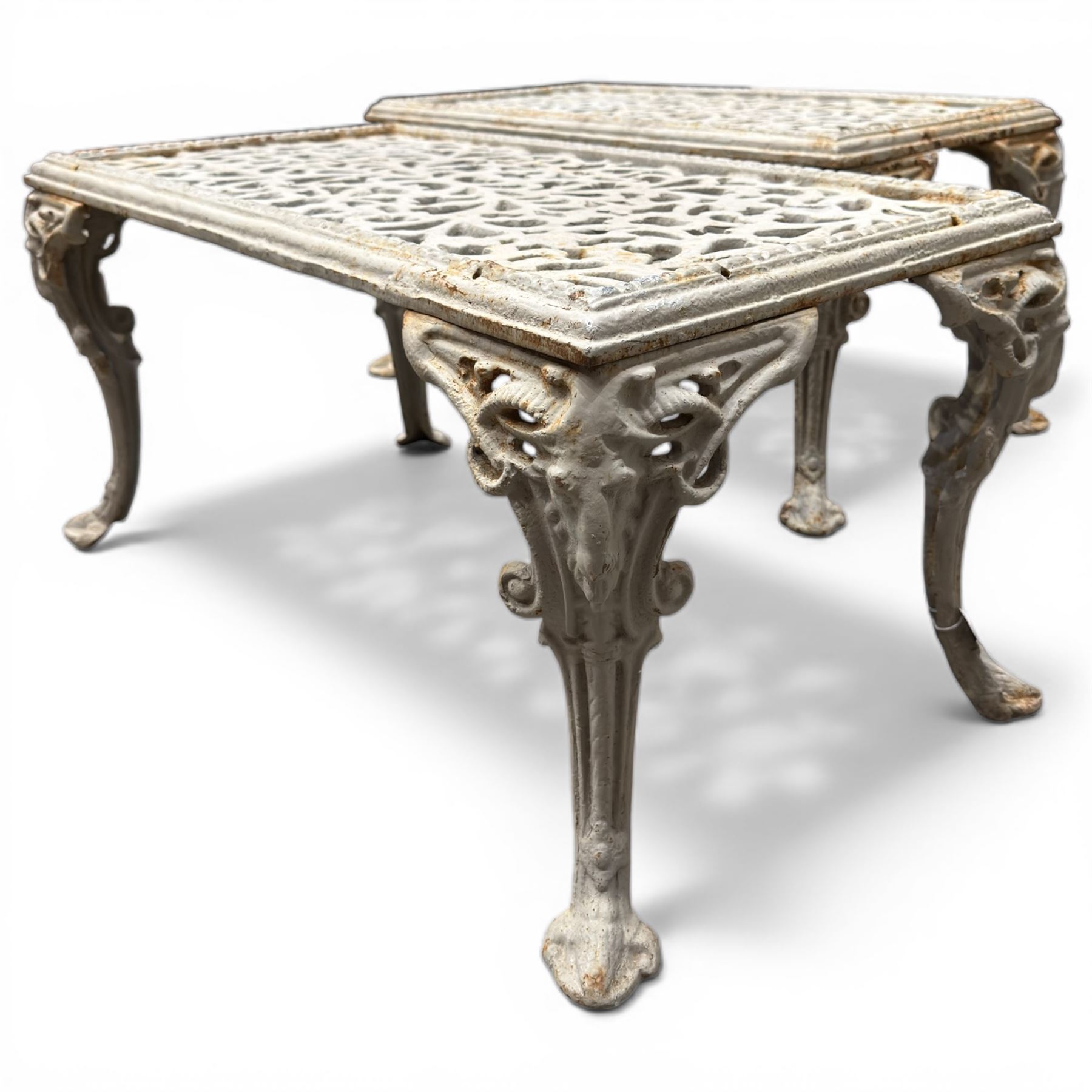 Pair of cast iron low garden tables with rams head legs in a white finish