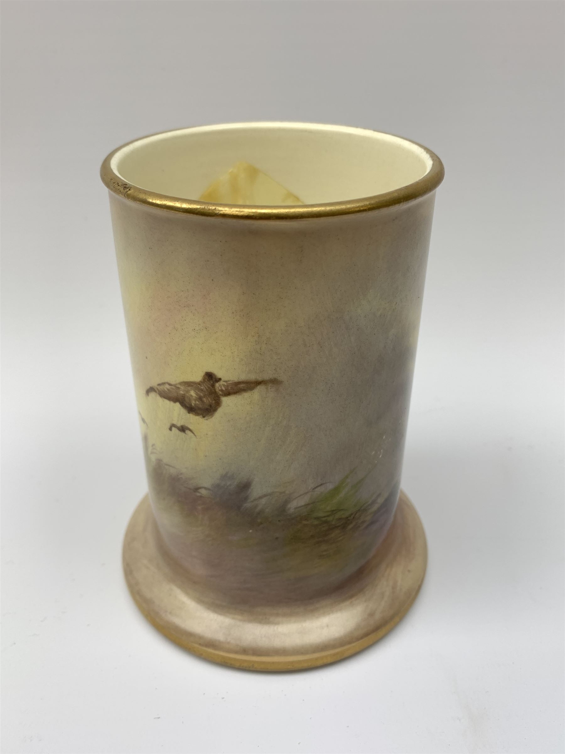 A Crown Devon Fieldings vase, of cylindrical form painted with a highland cattle scene and signed Cox, with printed marks beneath, H11.5cm