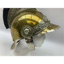 Early 20th century French mounted gendarme's helmet, brass with nickel-silver mountings, broad band embossed with fused grenade, high comb with the face of the gorgon Medusa at the peak and with a black horse hair crest, plume socket at the left, leather-backed nickel-silver chin scales with lion mask mounts.