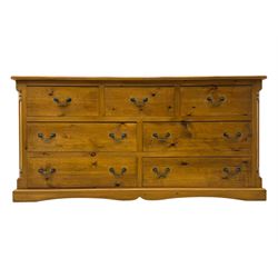 Pine dresser, rectangular top above seven drawers, with two smaller drawers over five larger drawers, all fitted with cast metal handles, raised on a shaped plinth base

