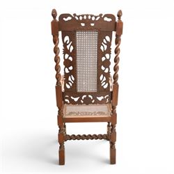 Late Victorian Jacobean Revival oak armchair, the caned back within a pierced and carved foliate frame surmounted by acorn finials, carved scroll arm supports, caned seat, on barley twist supports united by stretchers and carved front rail