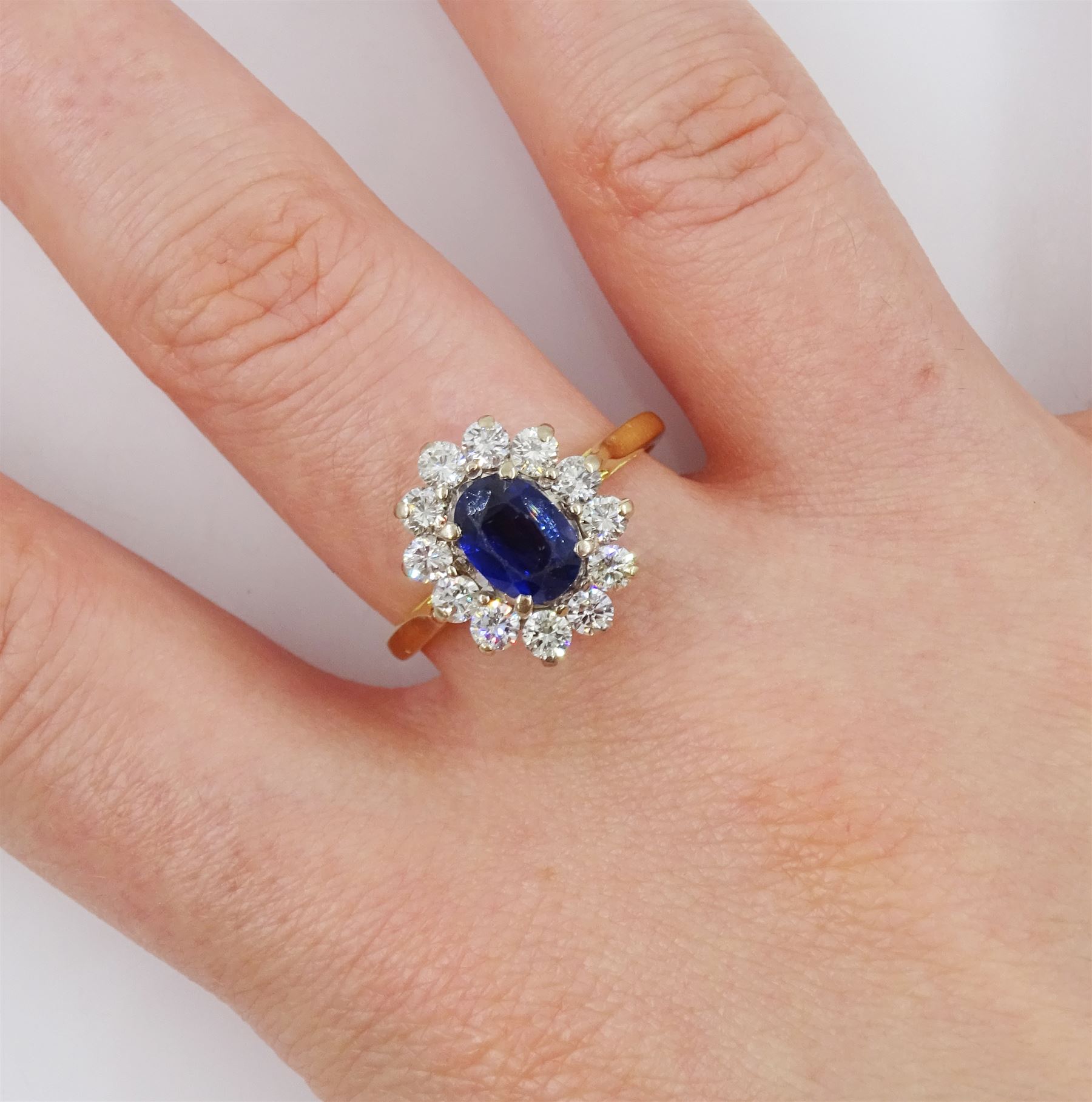18ct gold oval sapphire and round brilliant cut diamond cluster ring, Birmingham 1994, sapphire approx 1.00 carat, total diamond weight approx 0.70 carat
