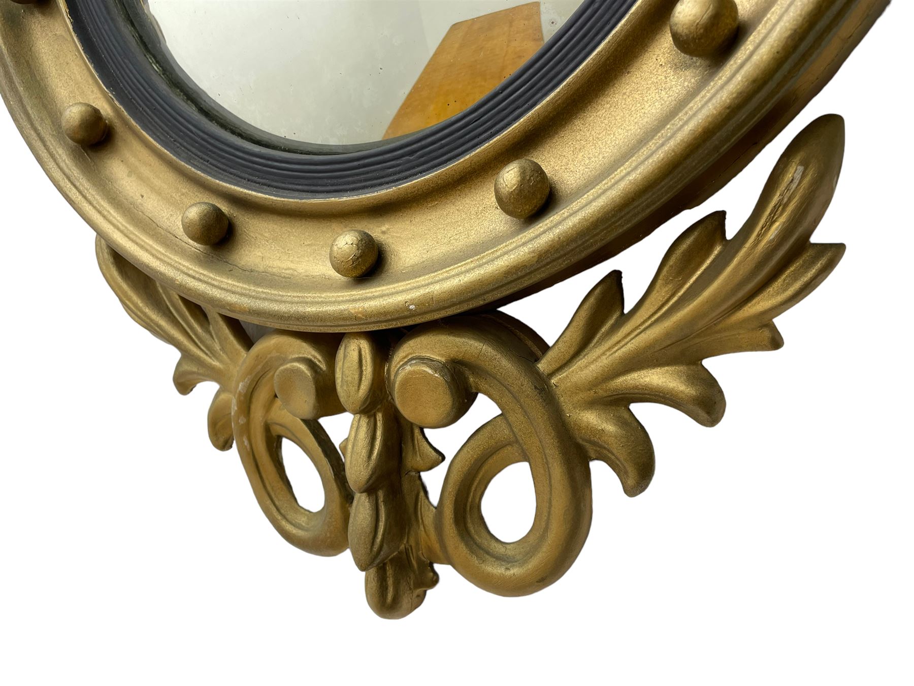Pair of Regency period giltwood convex wall mirrors, moulded circular frame decorated with spherical mounts surmounted by a carved eagle with spread wings, foliage scroll carved upper and lower brackets, reed moulded and ebonised slip enclosed convex mirror plate 
