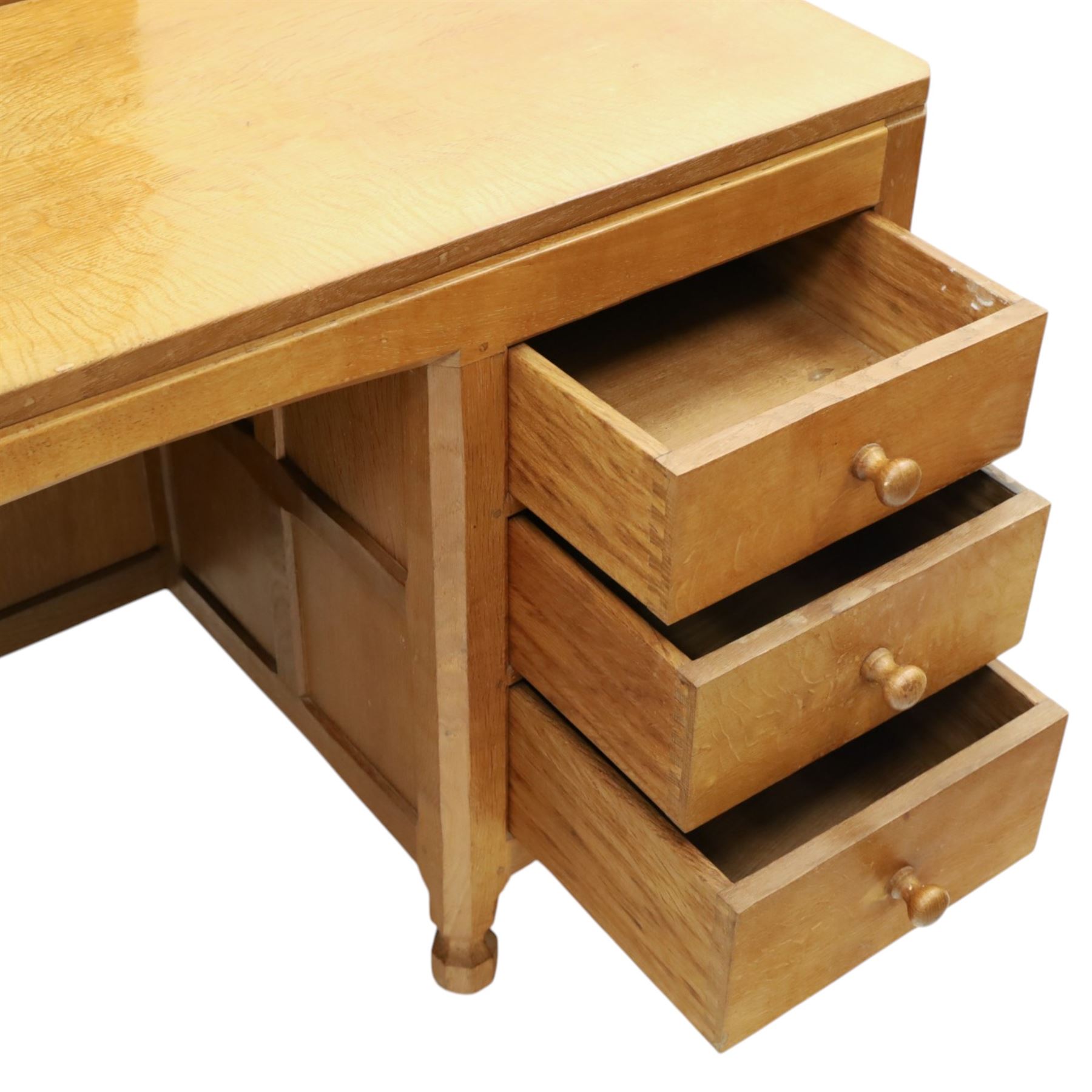Mouseman - adzed oak kneehole dressing table with mirror, the rectangular adzed top with raised back and canted corners with fixed central pivoting mirror with scallop-carved cresting rail, over an arched recessed kneehole flanked by three graduating drawers to each side with turned knob handles, raised on octagonal feet, with carved mouse signature, by the workshop of Robert Thompson of Kilburn