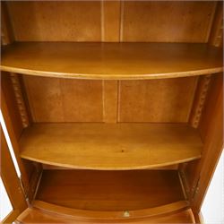 Wesley Barrell - French cherry wood bow front display cabinet, the upper section with glazed doors and three adjustable shelves, raised on cupboard base with brushing slide and further adjustable shelf, raised on a moulded plinth base with bracket feet