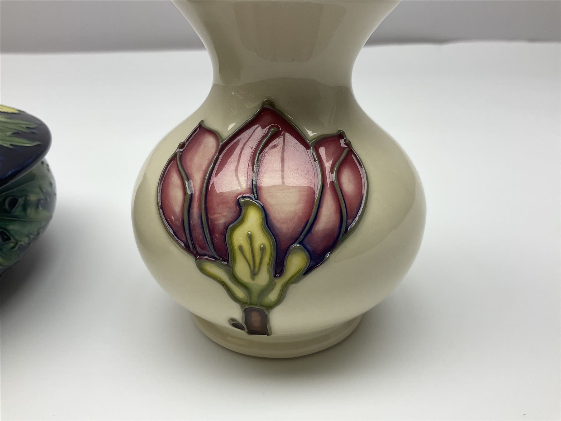 Moorcroft dish and cover, of circular form, decorated in Buttercup pattern, together with a Moorcroft vase, of baluster form, decorated in Magnolia pattern, both with printed marks beneath, tallest H9.5cm