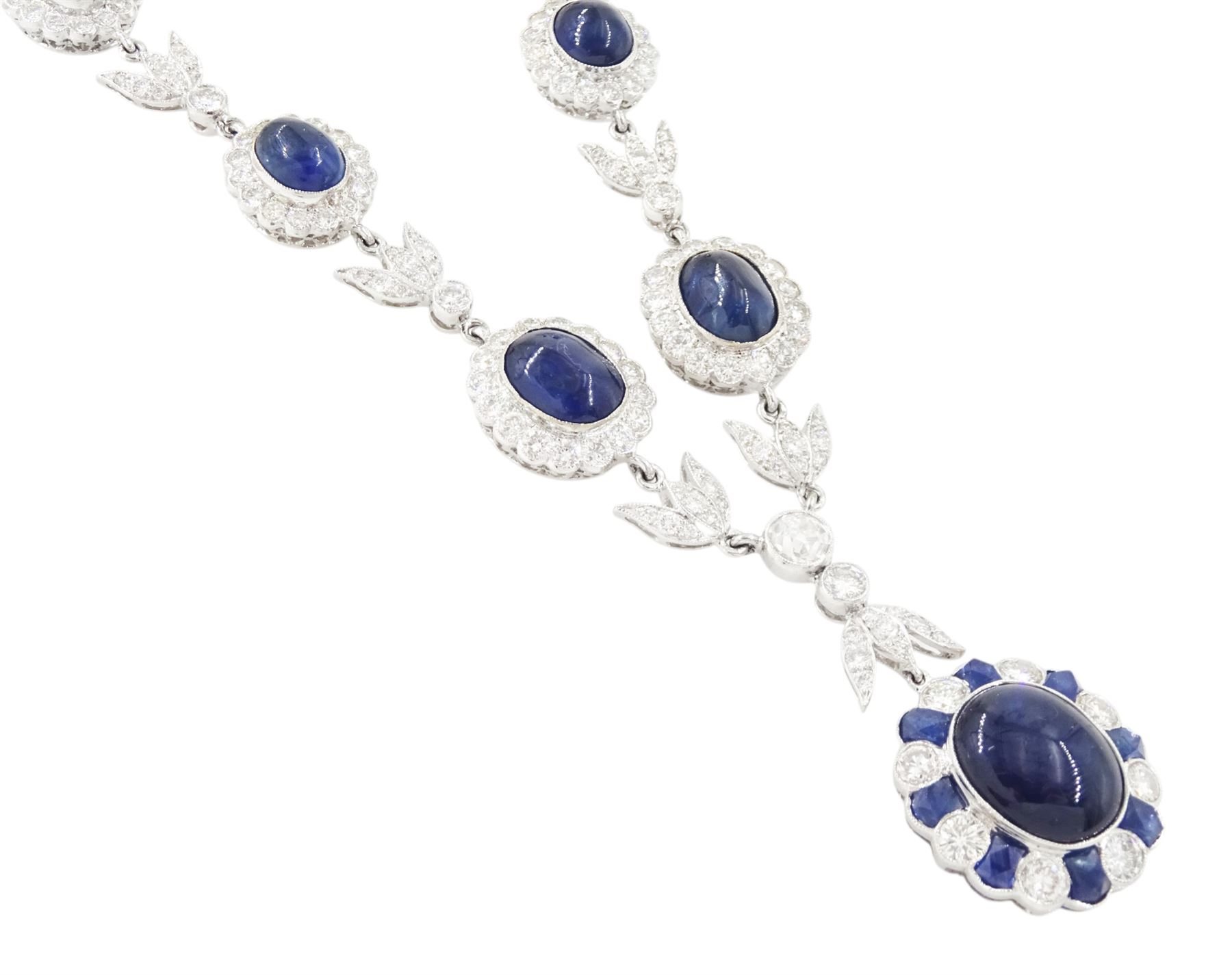 18ct white gold sapphire and diamond milgrain set necklace, oval cabochon cut sapphire surrounded by eight round brilliant cut diamonds and eight French cut sapphires, suspending from a diamond set leaf pendant, single round brilliant cut diamond and a larger old cut diamond, the chain set with six graduating cabochon cut sapphires, each surrounded by diamonds and spaced by a single diamond and a diamond set leaf, to a belcher link chain necklace, hallmarked, total sapphire weight approx 27.00 carat, total diamond weight approx 7.50 carat
