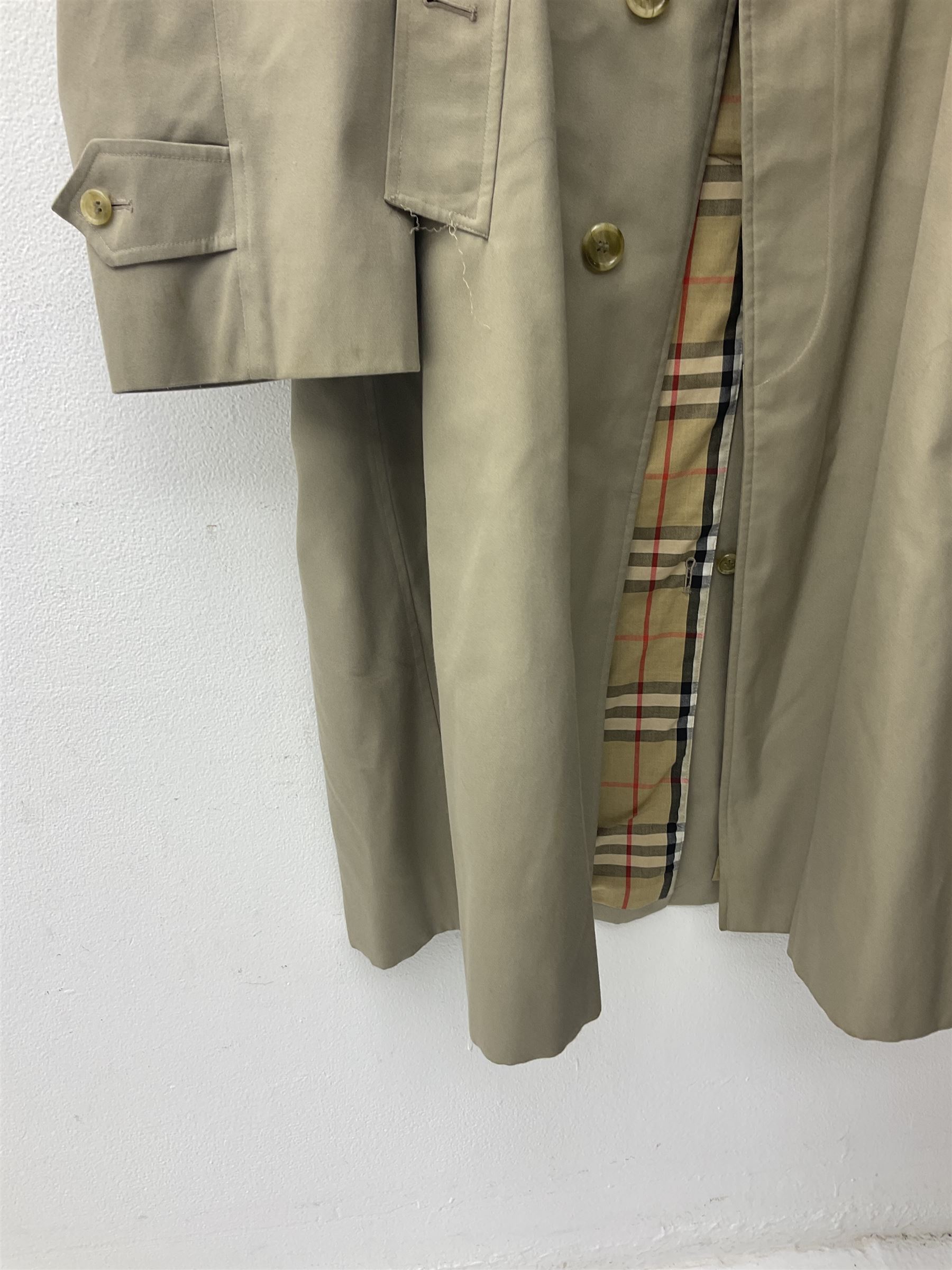 Ladies Burberry double breasted trench coat, with belt and detachable woollen gilet, in traditional cream colour with Burberry check lining, together with a gentlemans Burberry single breasted trench coat, both L112cm
