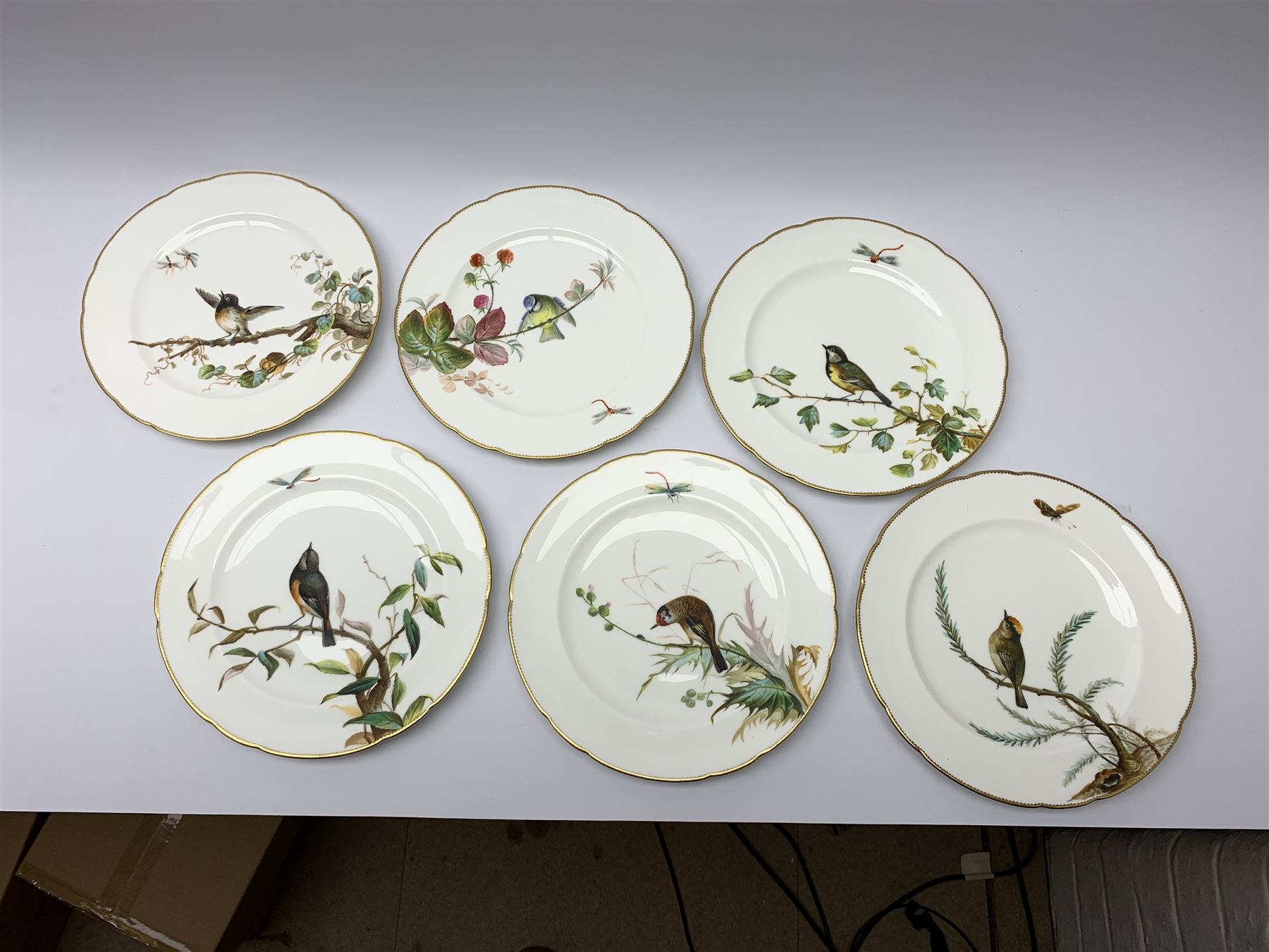 19th century Minton dessert service, comprising four comports, one tazza, and twelve plates, each hand painted with birds perched upon branches, and further detailed with insects and heightened in gilt, with printed retailers mark beneath for John Mortlock Oxford Street London, and impressed Minton mark to most, comport H13.5cm, plates D23.5cm. 
