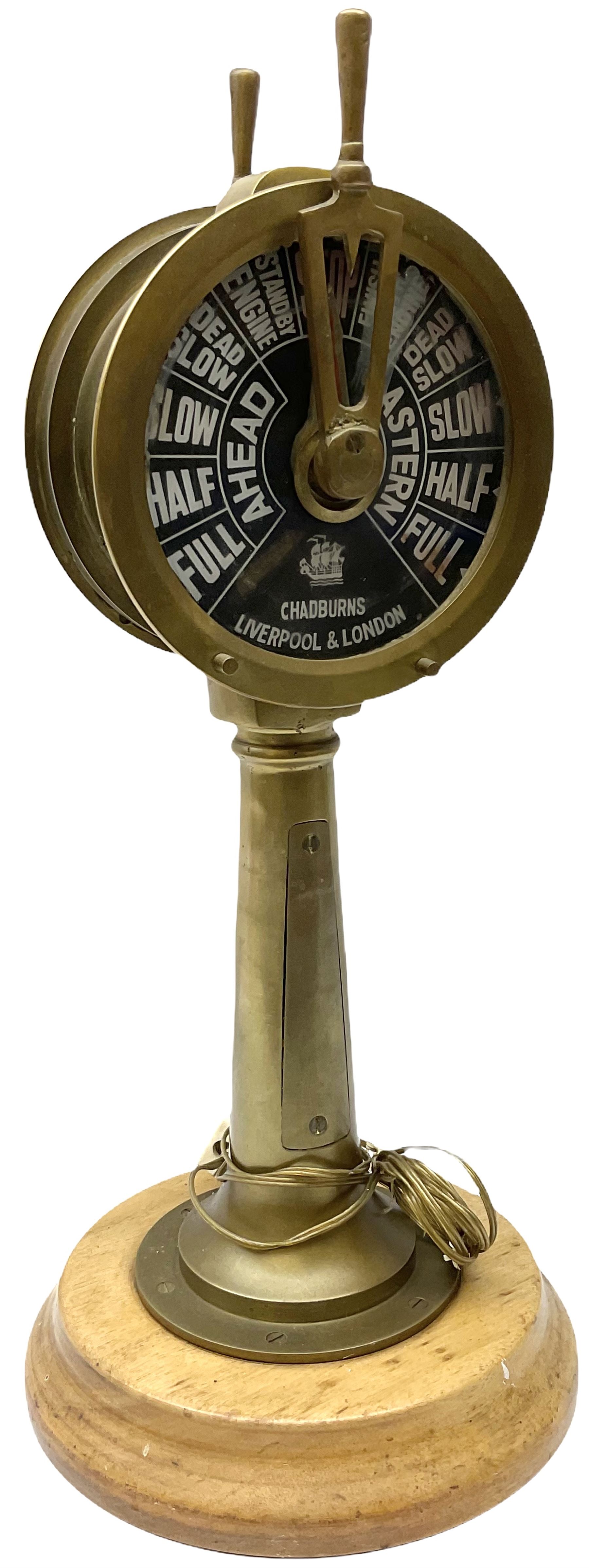 Early 20th century, illuminating brass ship's telegraph by Chadburns of Liverpool and London, on a circular wooden plinth, H55cm