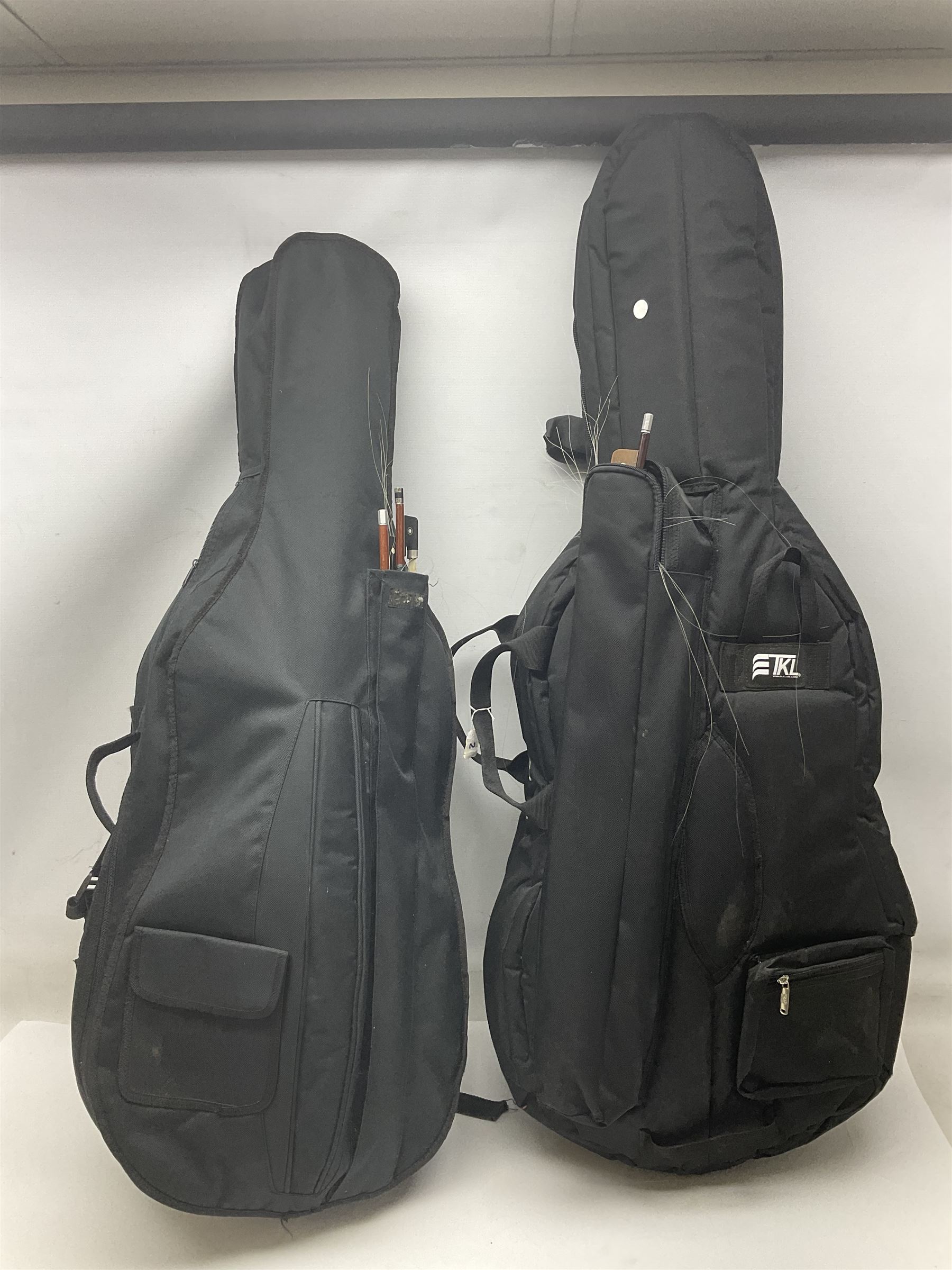 Two student half-size cellos - Boosey & Hawkes Artia with 65cm one-piece back and spruce top; bears maker's label; L104cm overall; and Romanian with 65.5cm two-piece maple back and ribs and spruce top; bears label; L108.5cm overall; each in soft carrying case with two bows (2)