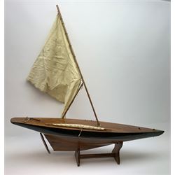 Pond yacht with part black painted mahogany hull and keel, working rudder and mast with three sails W90cm H95cm, loose mounted on mahogany stand