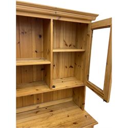 Waxed pine dresser, raised back fitted with two glazed cabinets, the base fitted with five drawers and two cupboards, plinth base