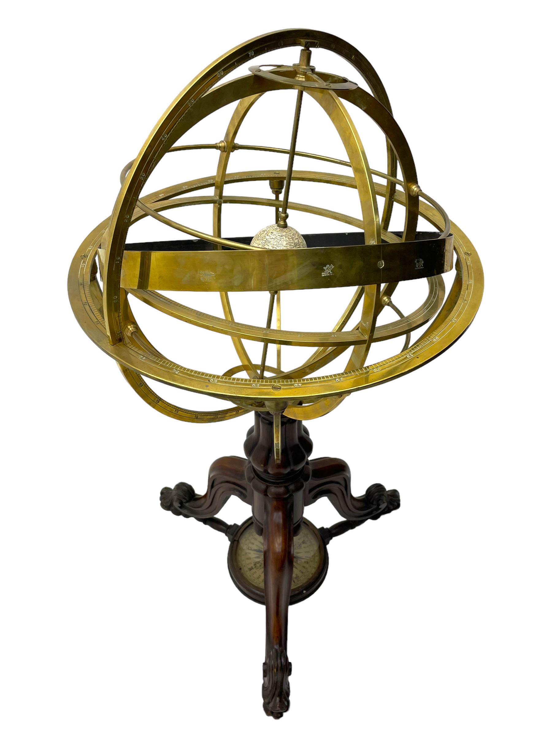 19th century brass terrestrial armillary sphere on rosewood base, lobe carved column on three splayed supports with scrolled carved terminals, the supports united by circular compass with turned stretchers