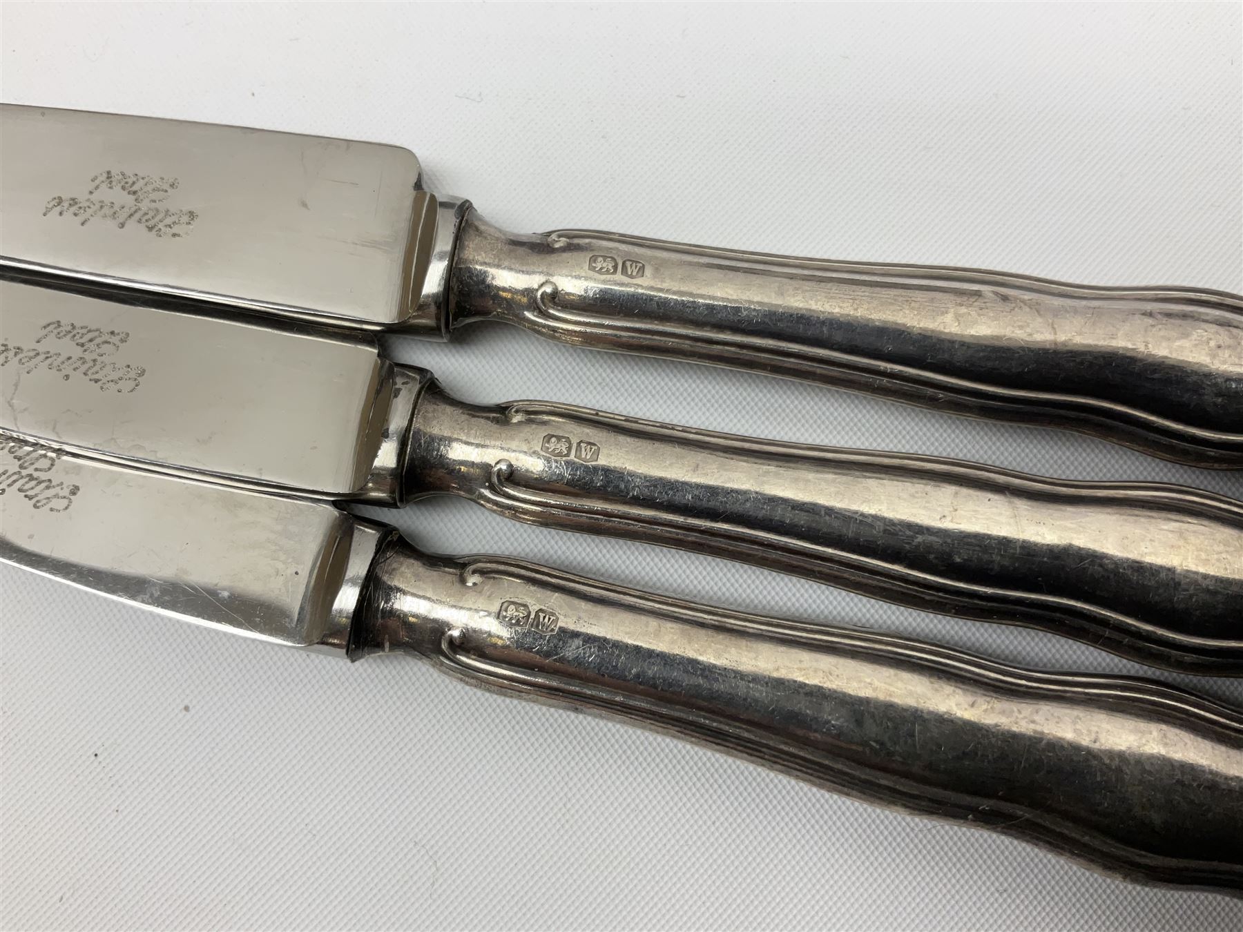 Two silver napkin rings, silver spoon with thistle top terminal, two silver handled butter knives, and small glass jar with silver cover, all hallmarked, approximate weighable silver 53.7 grams