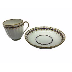 Early 19th century Derby teacup and saucer, circa 1806-1825, of fluted form, each painted with blue bands and gilt foliate tendril bands, with red painted mark beneath, teacup H7cm saucer D13.5cm
