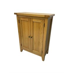 Solid light oak cupboard, fitted with two panelled doors enclosing two shelves, on tapered feet