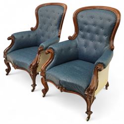 Fine pair of mid-19th-century mahogany library armchairs, carved frame with balloon-shaped back with scrolled ends, rolled wide arms, ending in a scrolled volute above a serpentine seat rail, upholstered in mottled turquoise faux leather, button upholstered back, arms, and cushion seat, studded sides and apron, raised on scroll carved front feet and splayed rear legs on castors 